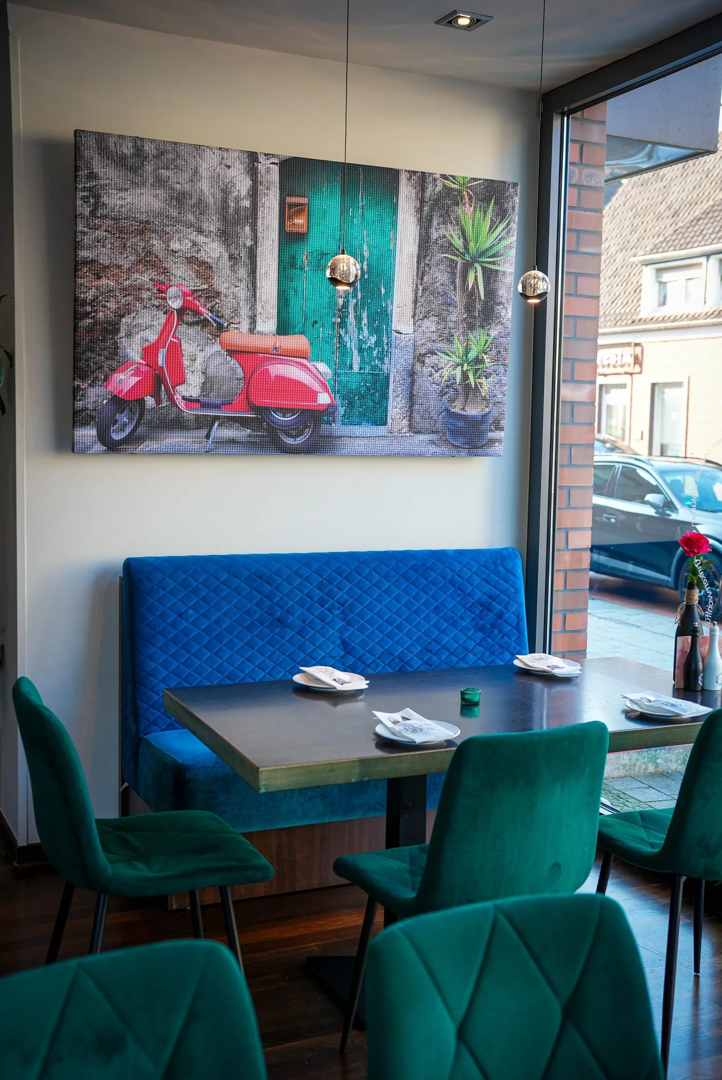 Sitzecke mit blauer Bank, Samtstühlen und Vespa Bild im Ristorante La Rosa