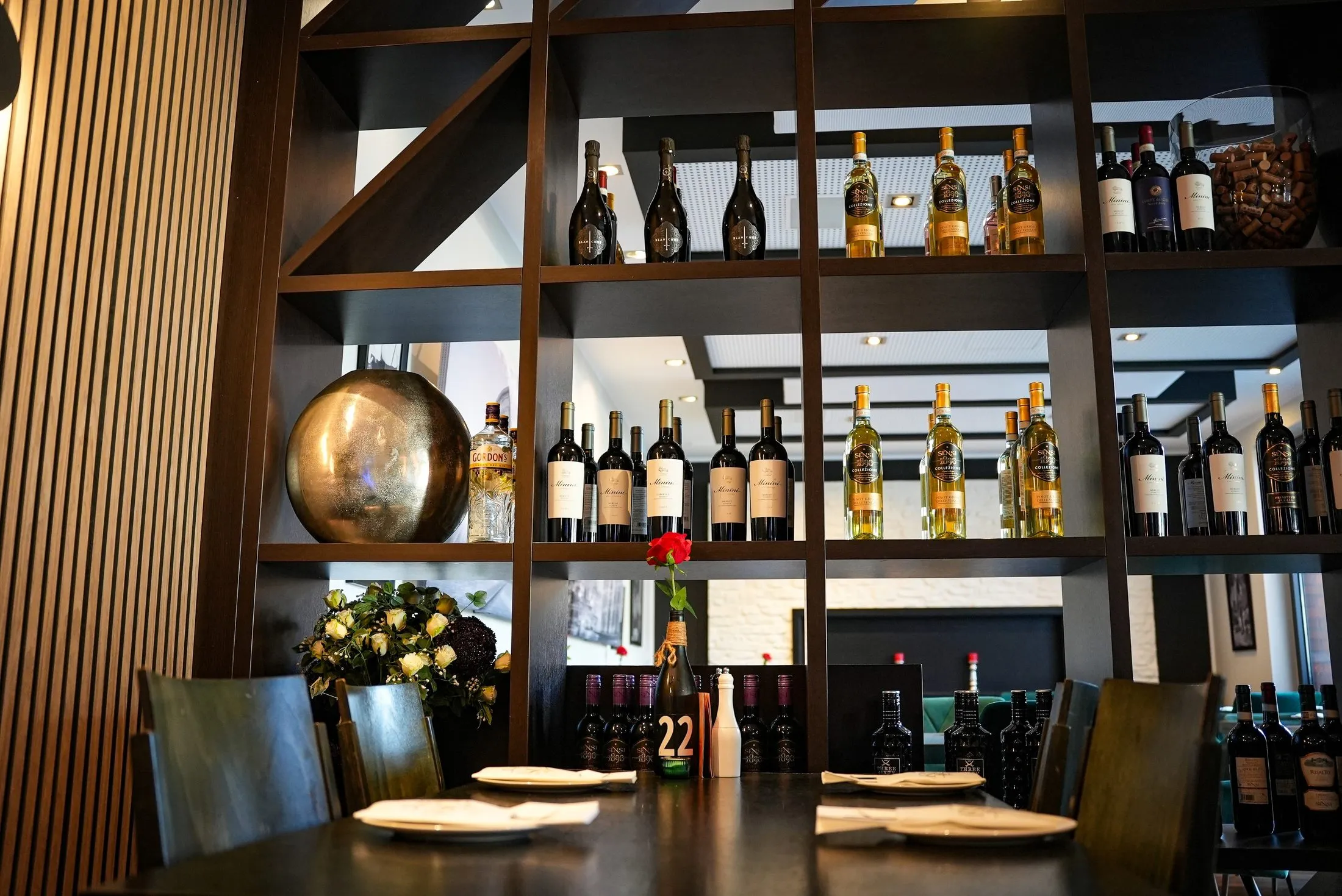 Weinregal mit gedeckten Tischen im Ristorante La Rosa